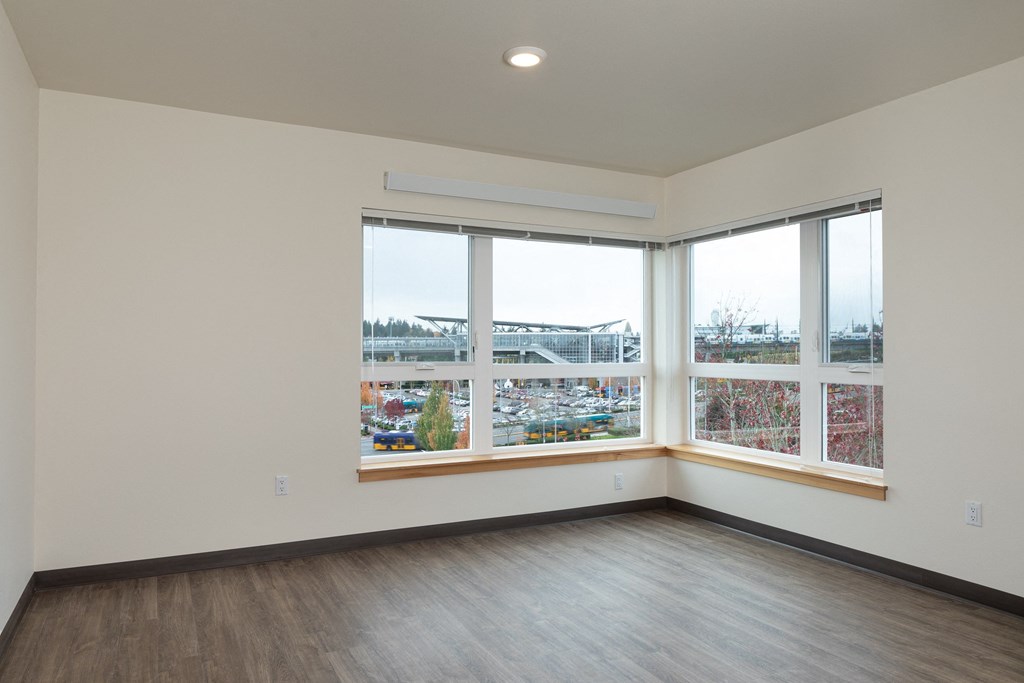 A room with a large window overlooking a parking lot.