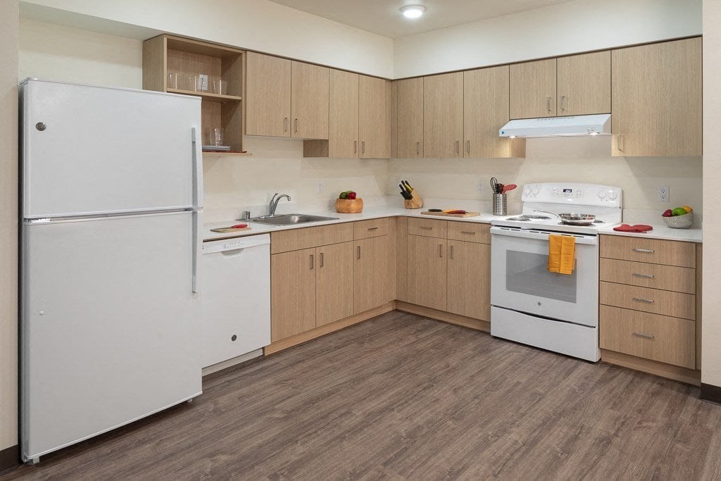 A kitchen with a white refrigerator and white stove.
