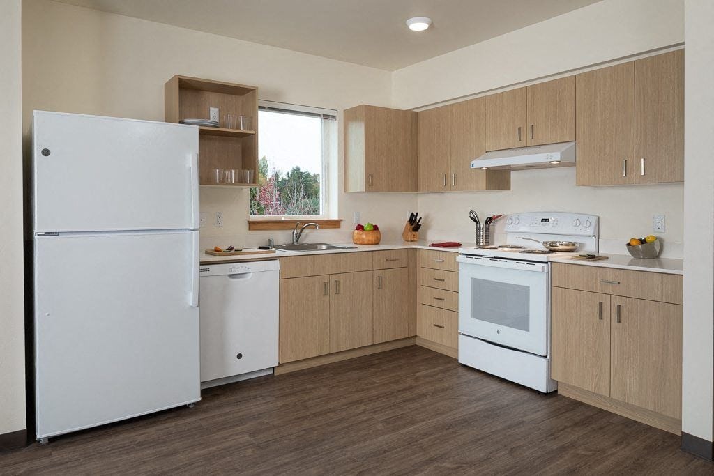A kitchen with white appliances and wooden cabinets.