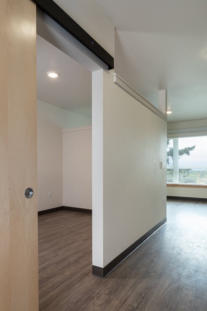 A room with a white wall and a wooden floor.