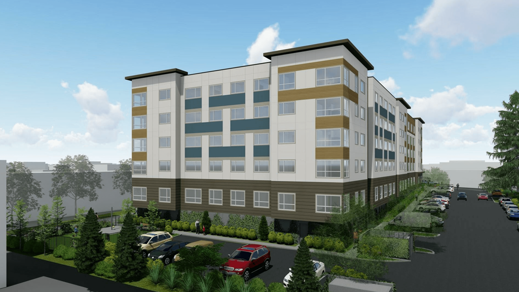 A modern apartment building with a parking lot in front.