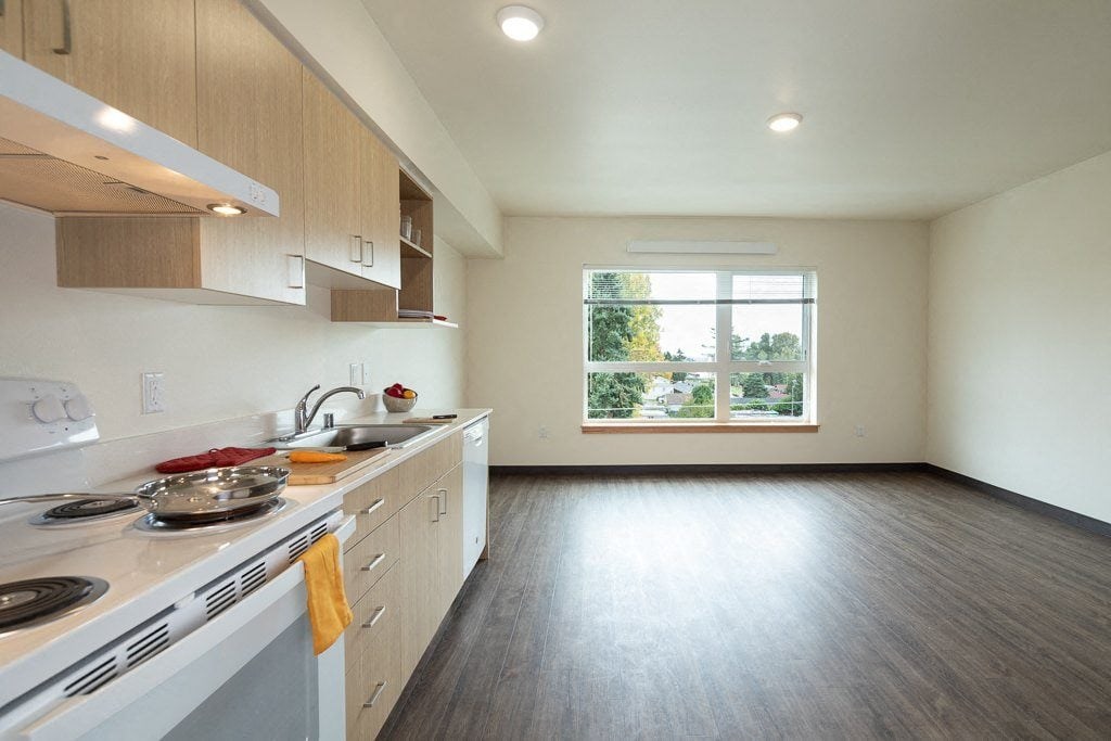 A kitchen with a stove top oven and a window.