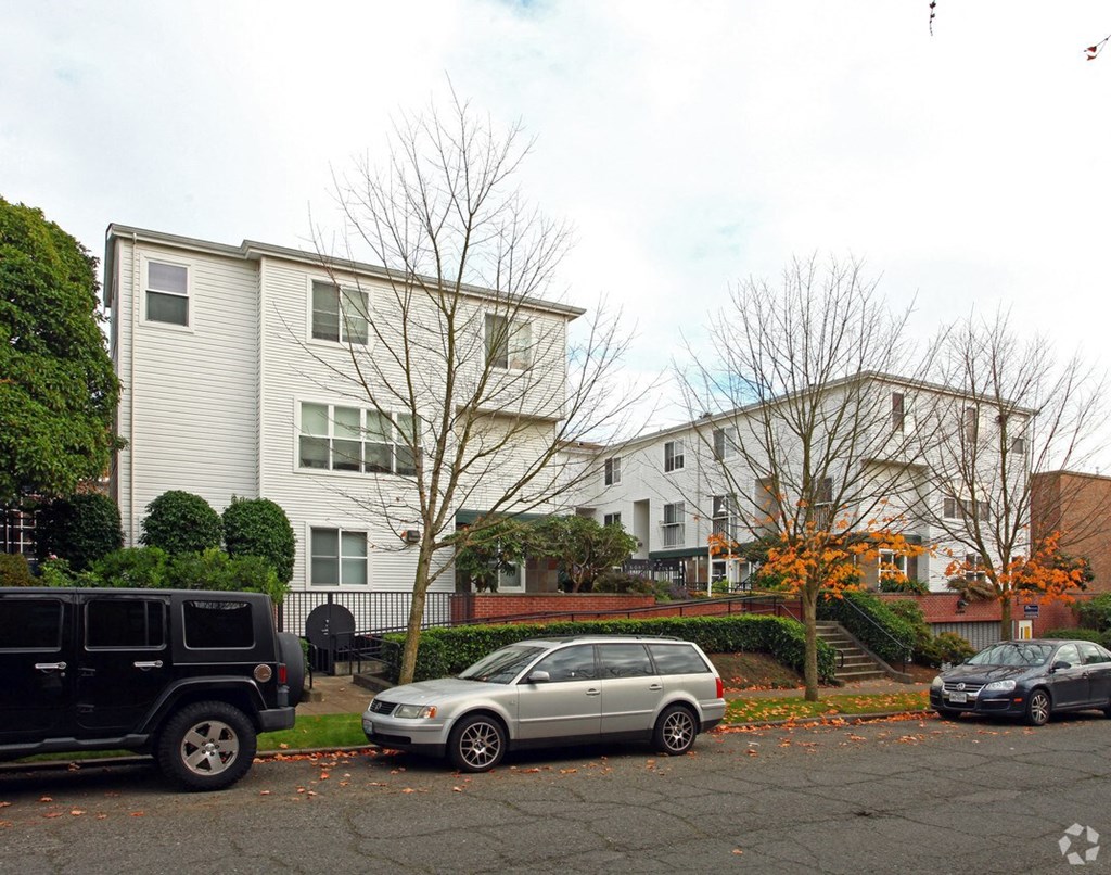 a group of houses with cars parked in front of them