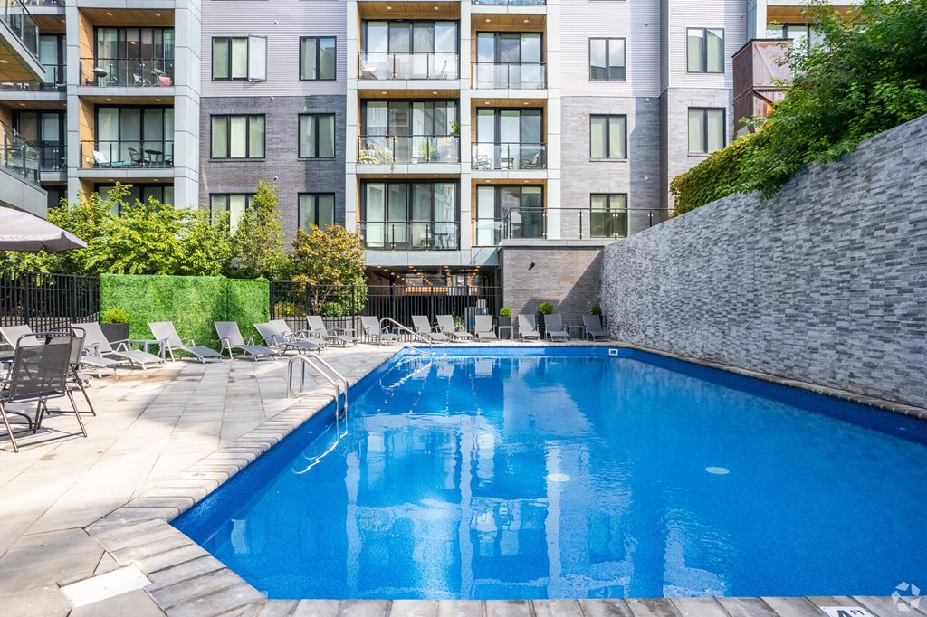A swimming pool in front of a residential building.