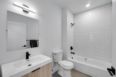 A white bathroom with a toilet, sink, and bathtub.