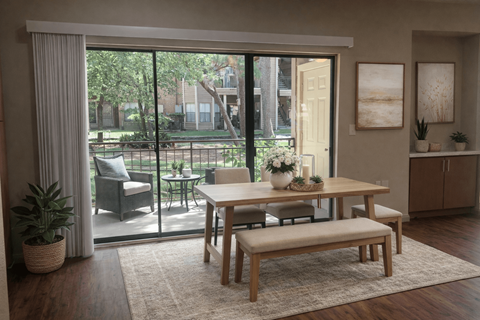 A dining room with a table and chairs and a view of a backyard.