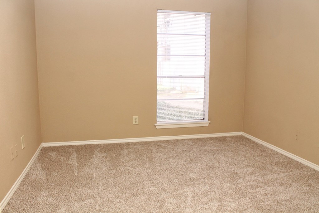 an empty room with carpet and a window