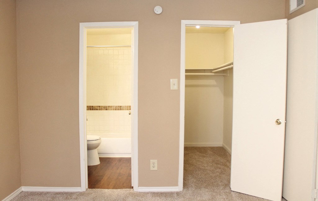 an empty bathroom with a toilet and a closet