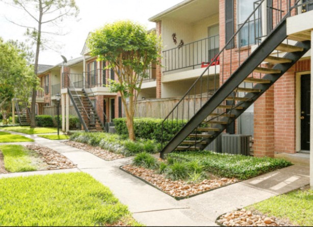 an exterior view of an apartment building with stairs and a sidewalk