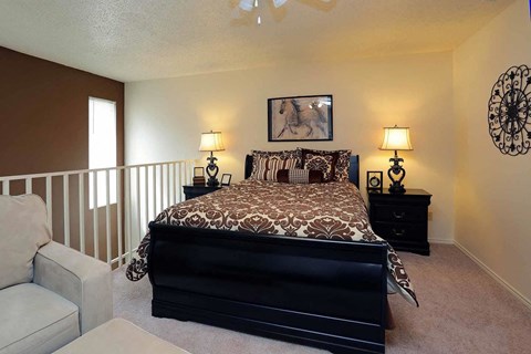 A bedroom with a large bed and a painting of a horse on the wall.