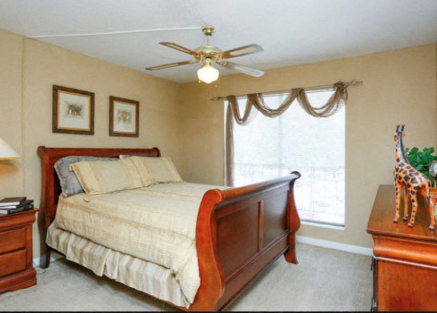a bedroom with a bed and a ceiling fan