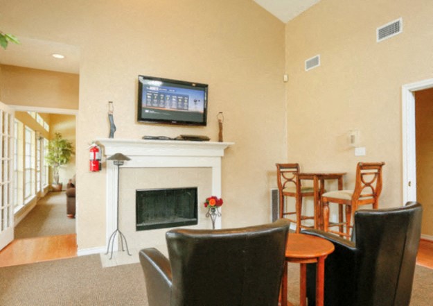 a living room with a fireplace and a table and chairs