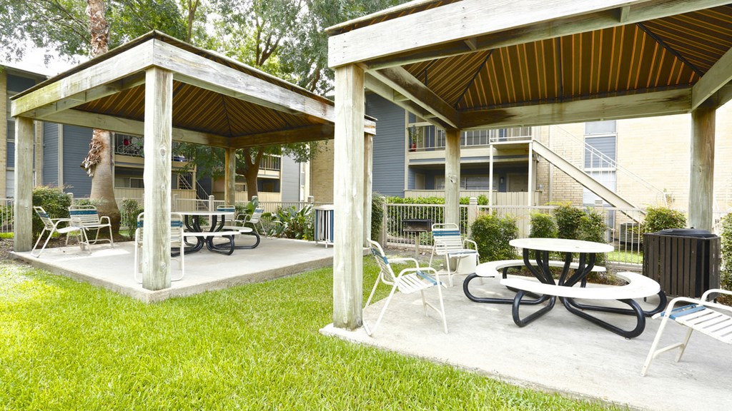 a patio with tables and chairs in front of a building