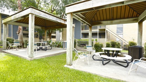 a patio with tables and chairs in front of a building