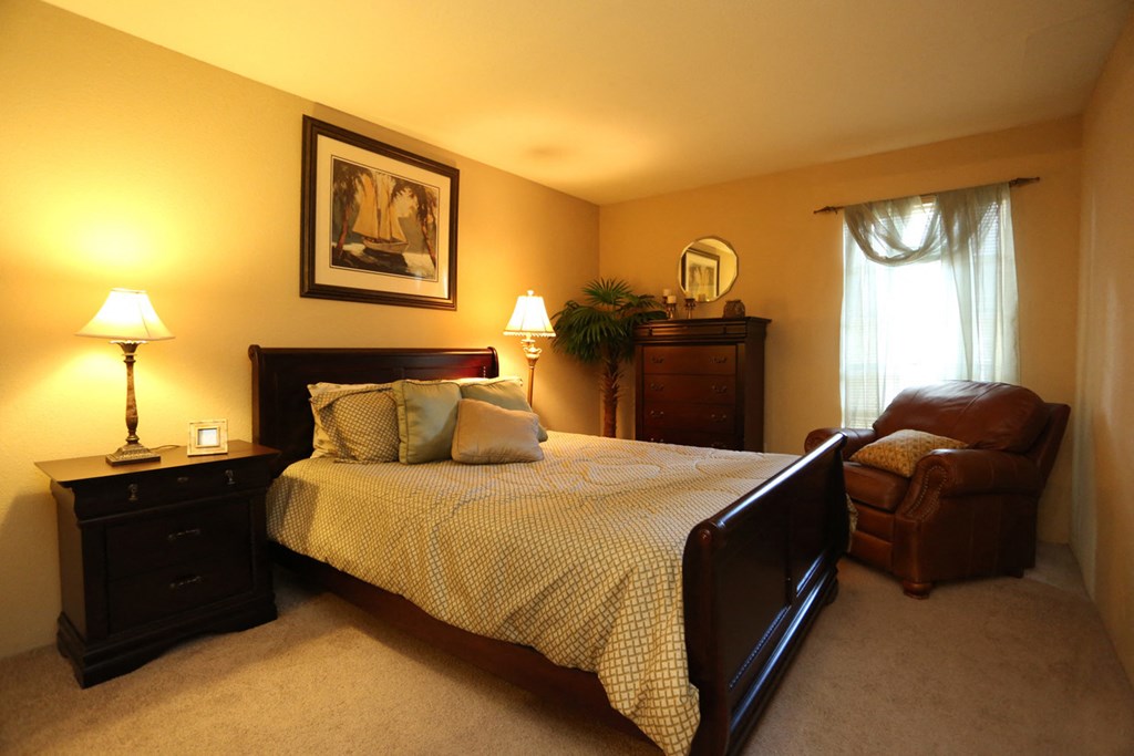 a bedroom with a bed and a chair