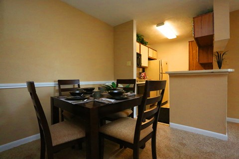 a dining area with a table and chairs and a kitchen