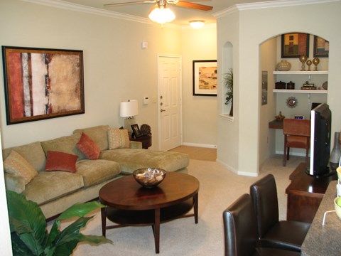 A living room with a couch, chair, and a painting on the wall.