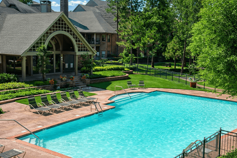 A large outdoor swimming pool surrounded by a black fence.