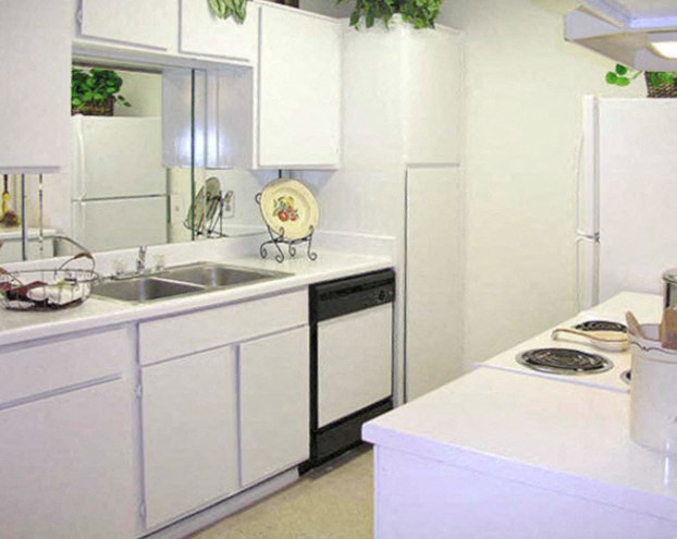 a white kitchen with a sink and a refrigerator