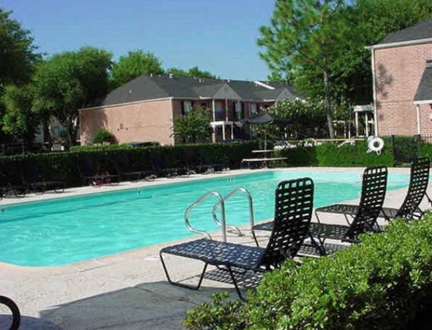 a swimming pool with three lawn chairs
