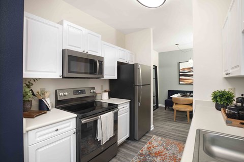 a kitchen with black appliances and white cabinets