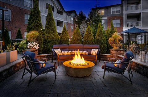 A cozy outdoor seating area with a fire pit in the center.