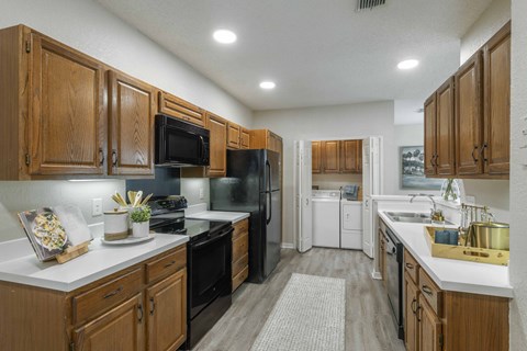 A kitchen with wooden cabinets and black appliances.