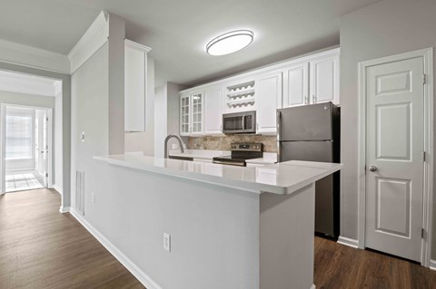 A kitchen with white cabinets and a white countertop.
