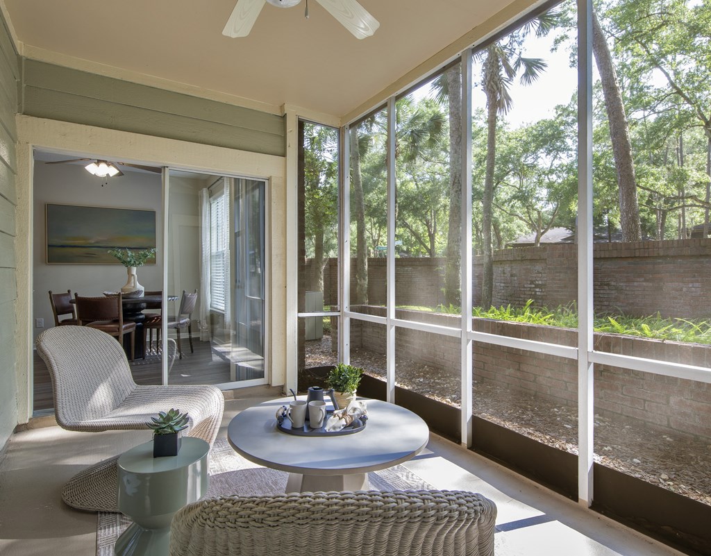 Longwood Sabal Park Apartments resort-inspired pool and expansive sundeck a patio with a table and chairs overlooking a garden.