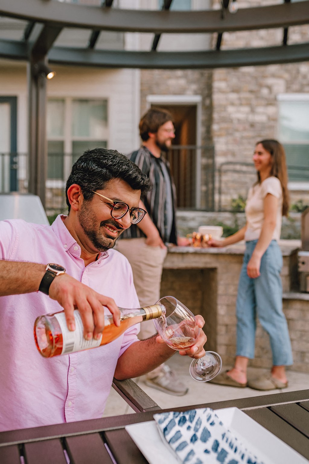 a man pouring wine into a glass at a bar