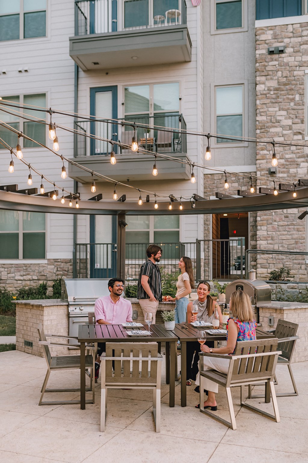 a group of people sitting around a table outside of a building