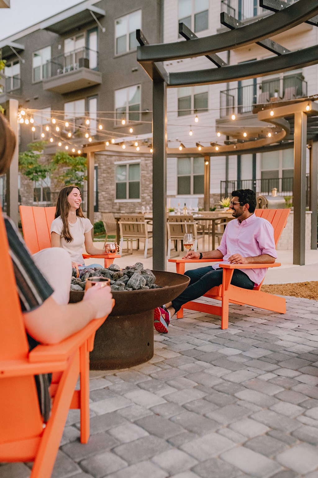 a group of people sitting around a fire pit on a patio