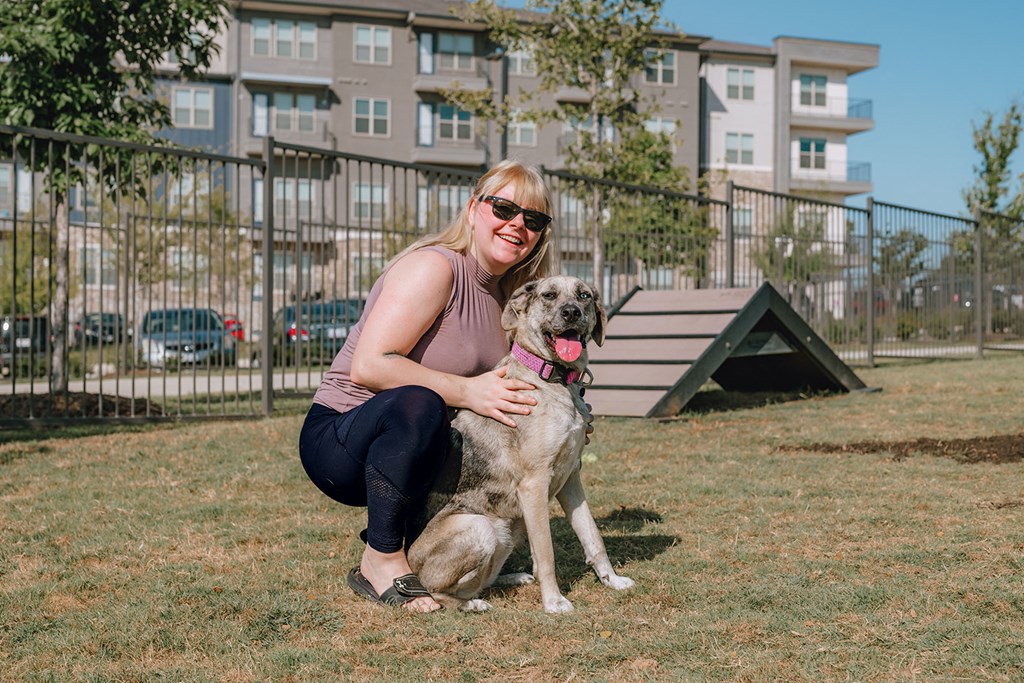 Westloop at the Diamond Interchange Irving TX woman kneeling down with a dog in the fenced Dog Park