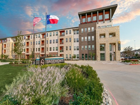 a building with two flags and a sign in front of it