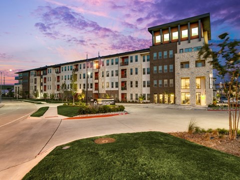 a rendering of a building with the facade lit up at dusk