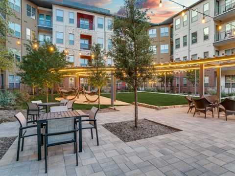 an open courtyard with tables and chairs in an apartment building