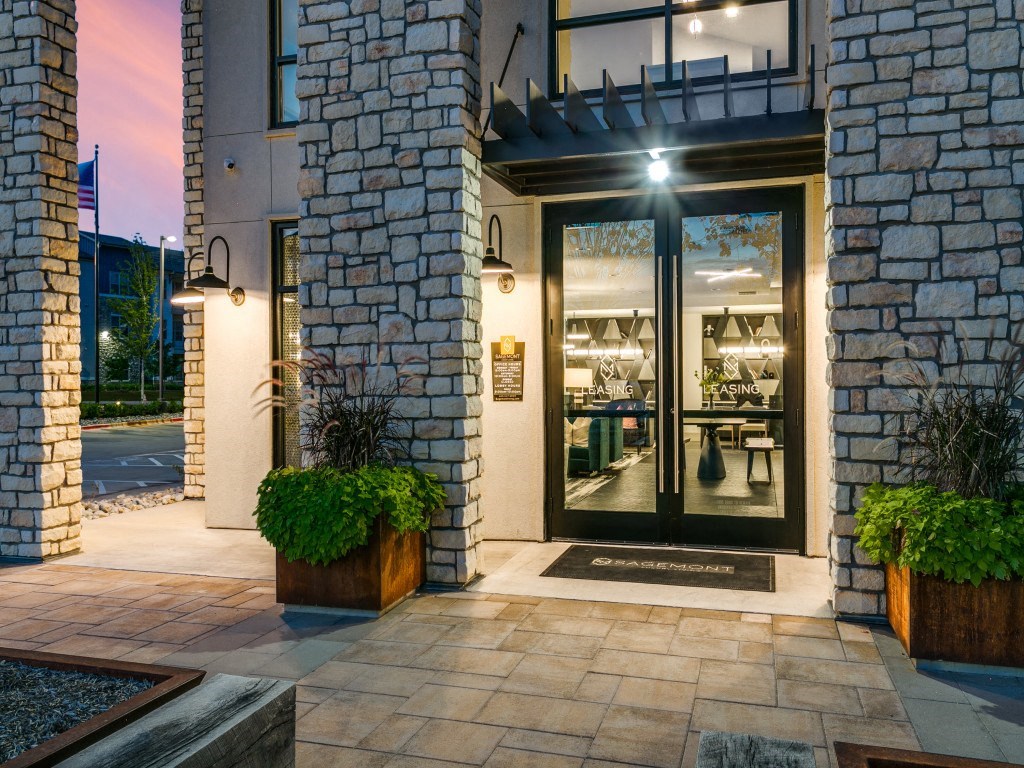 the front door of a store with glass doors and a glass window