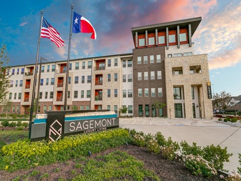 a building with two flags and a sign in front of it