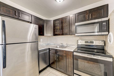 a kitchen with stainless steel appliances and black cabinets