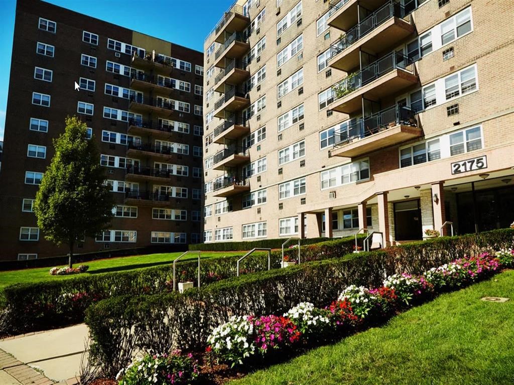 an apartment building with flowers in front of it
