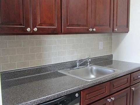 a kitchen counter with a sink and wooden cabinets