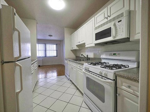 a kitchen with white appliances and white cabinets