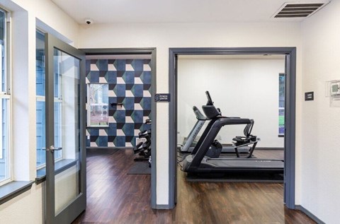 A treadmill is in a room with a checkered wall.