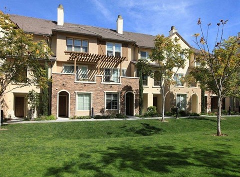 a large brick house with a green lawn
