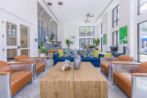 A modern living room with a wooden coffee table and orange leather chairs.