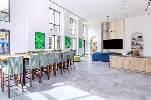 A modern dining room with a long table and chairs.
