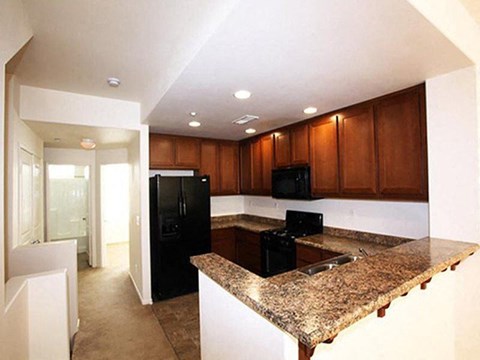 a kitchen with granite counter tops and black appliances
