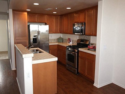 a kitchen with wooden cabinets and stainless steel appliances