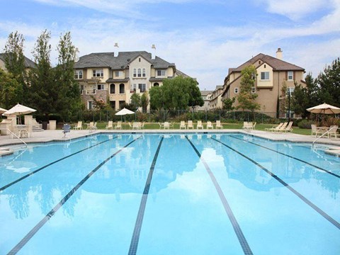 a large swimming pool with houses in the background