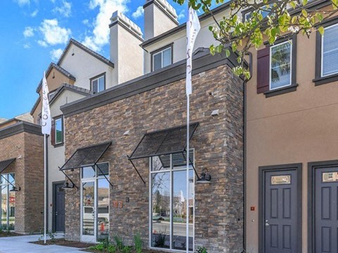 the front of a building with windows and a flag
